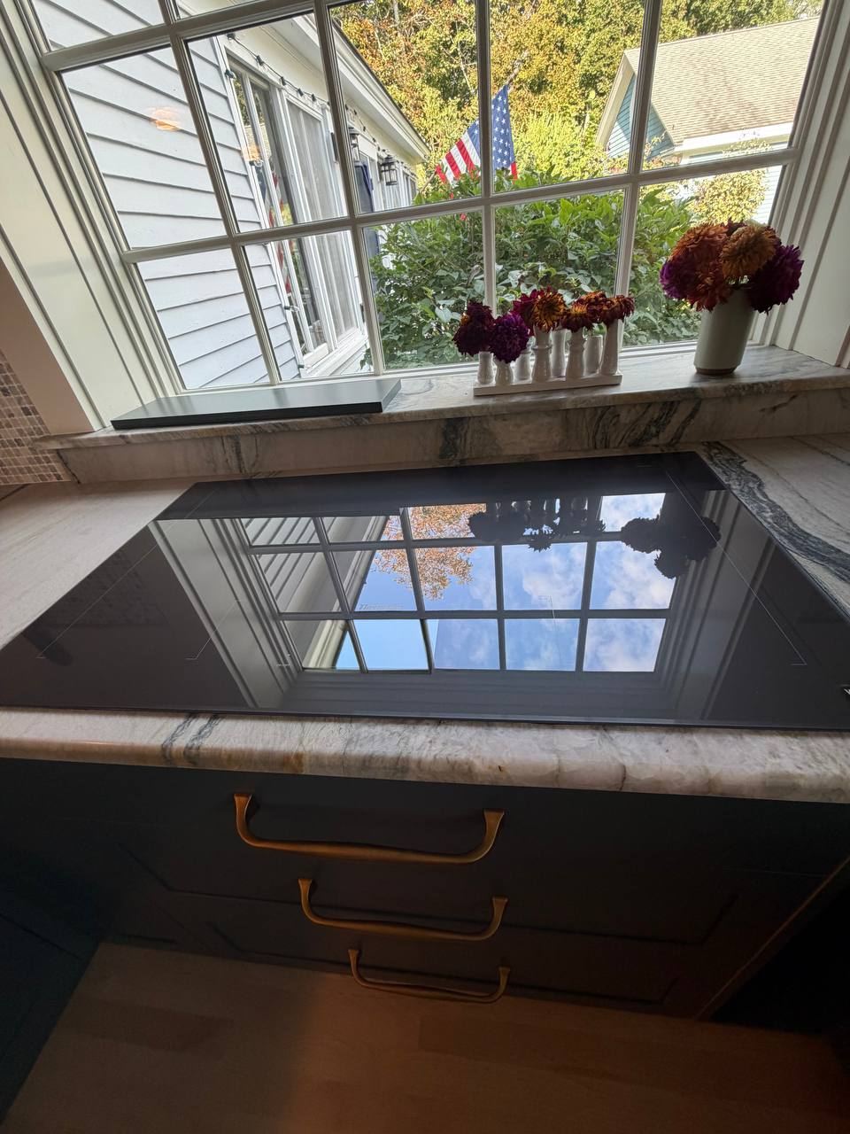 Streak-free glass cooktop reflecting the window