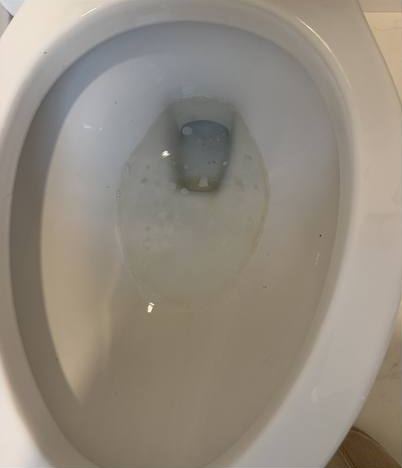 Toilet before cleaning, with buildup in the bowl